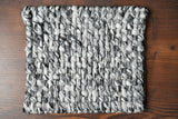 Grey mixture loop chunky wool rug styled in living room