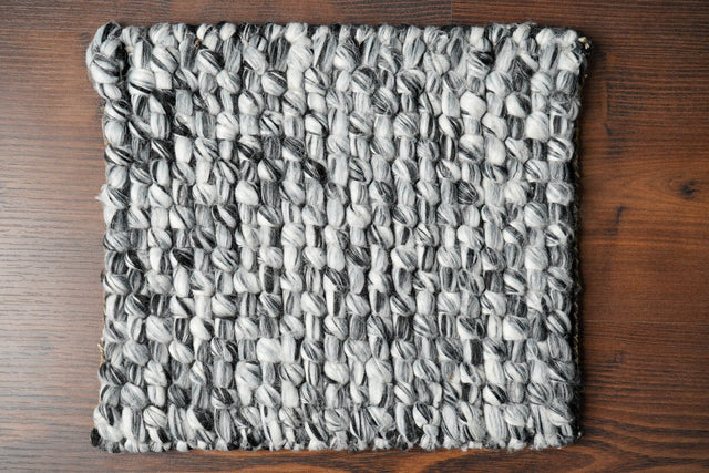 Grey mixture loop chunky wool rug styled in living room