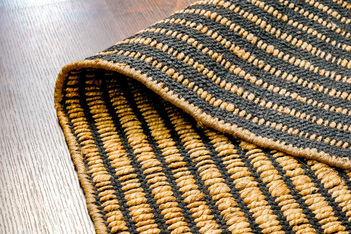 Black ribbed jute rug styled with furniture in room