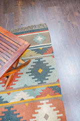 Full view of vintage kilim rug on wood floor
