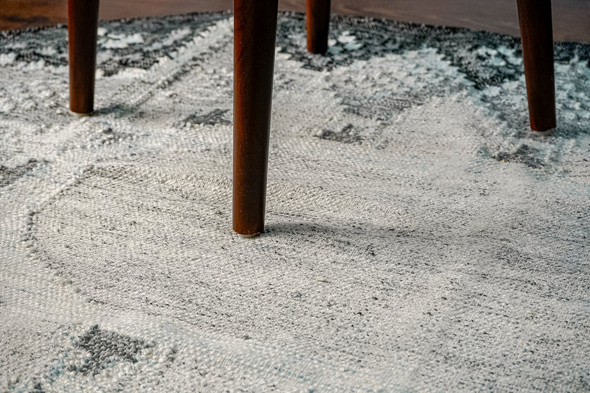 Gray oval rug corner detail showing edge binding