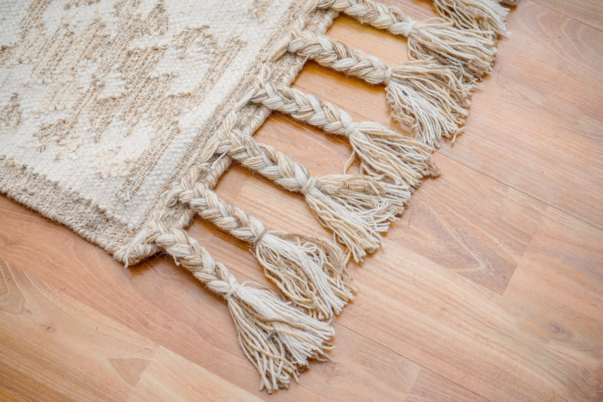 Close-up of handwoven texture on white kilim rug
