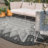 Gray oval kilim rug styled on a patio