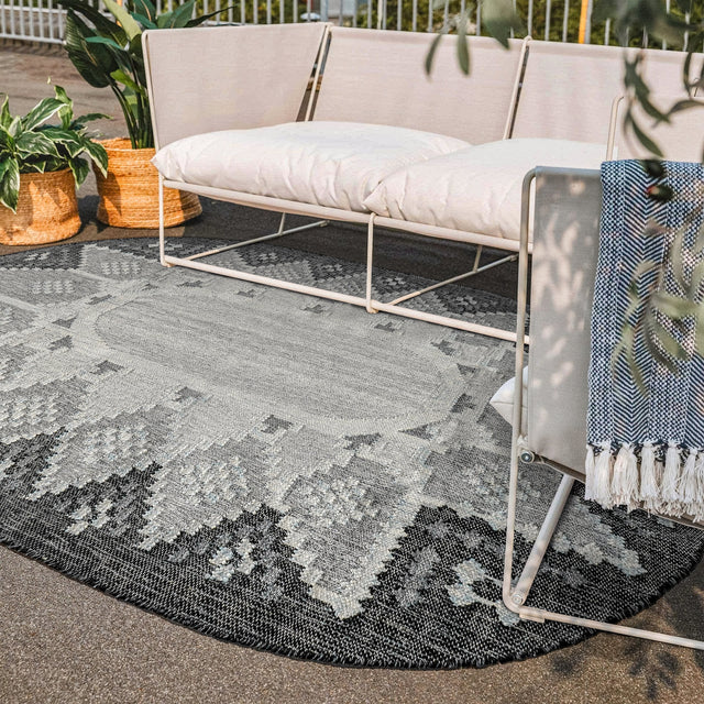 Gray oval kilim rug styled on a patio