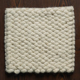 Handwoven chunky wool rug in a Scandinavian styled bedroom