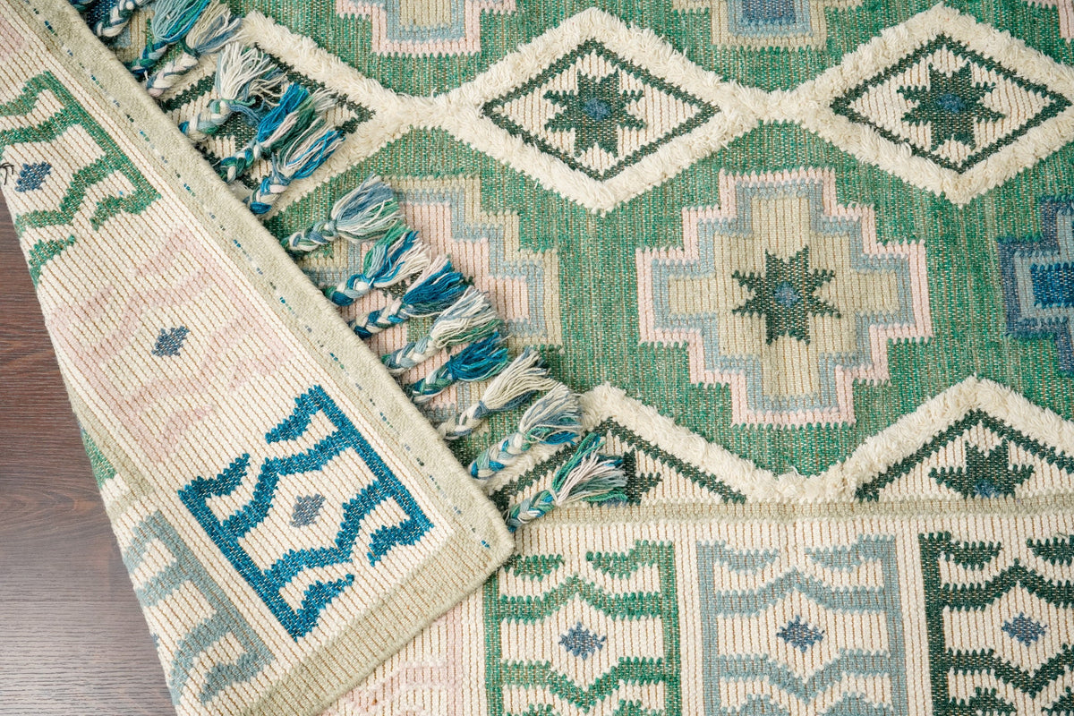 Sage green wool rug tassel fringe close-up
