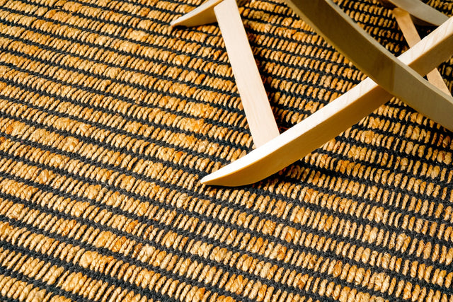 Natural jute rug with black ribbed accent, flat lay view