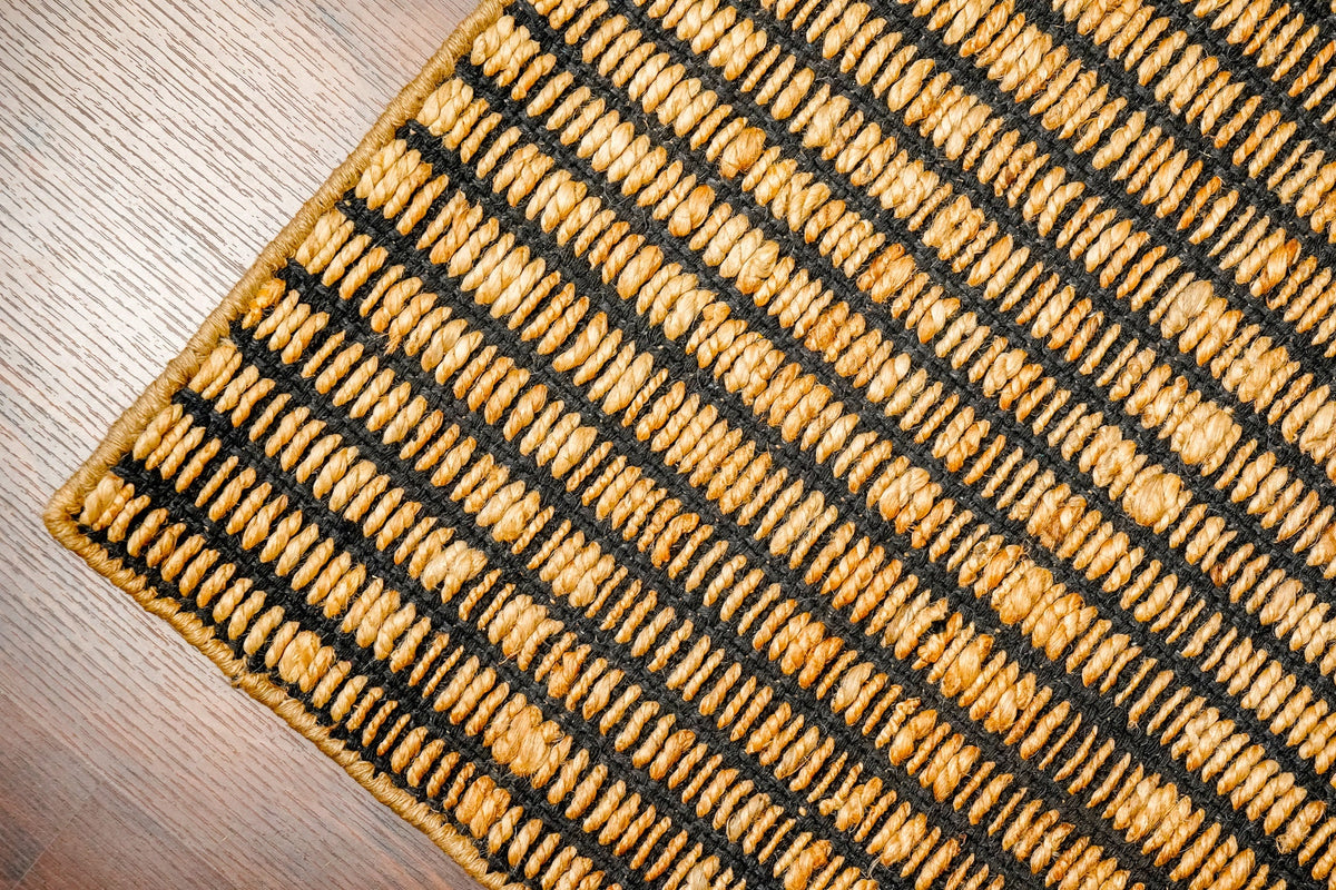 Black ribbed jute rug in a bedroom setting