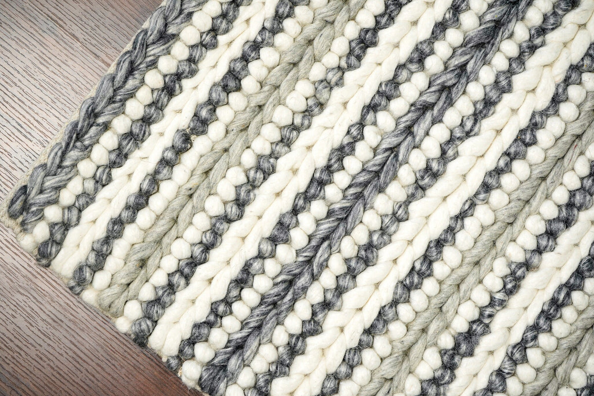 Grey and ivory chunky loop wool rug in bedroom setting