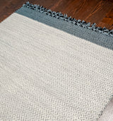 Corner detail of grey wool flatweave rug