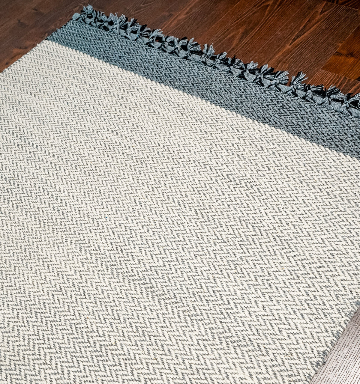 Corner detail of grey wool flatweave rug