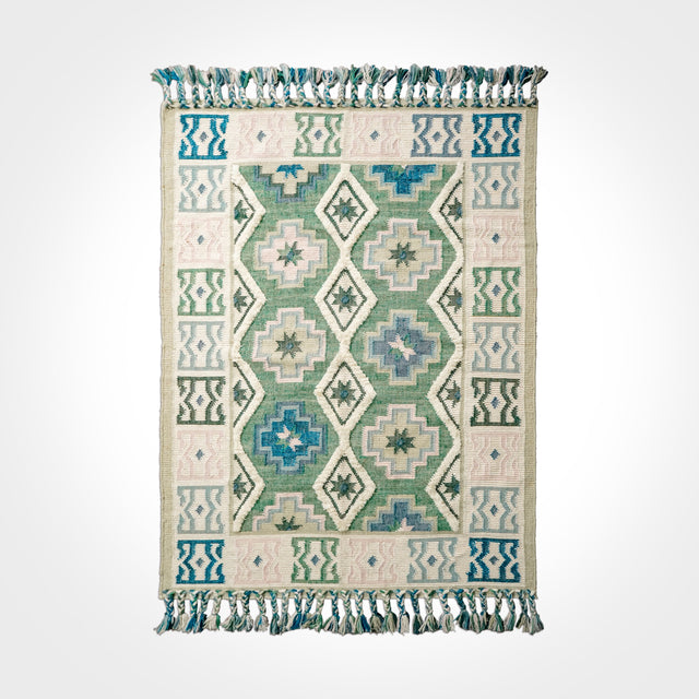 Green kilim rug styled in Scandinavian living room