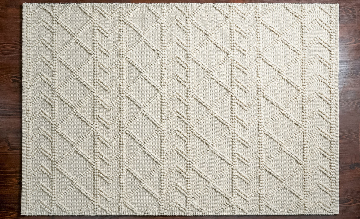 Abstract ivory chunky wool rug in bedroom setting