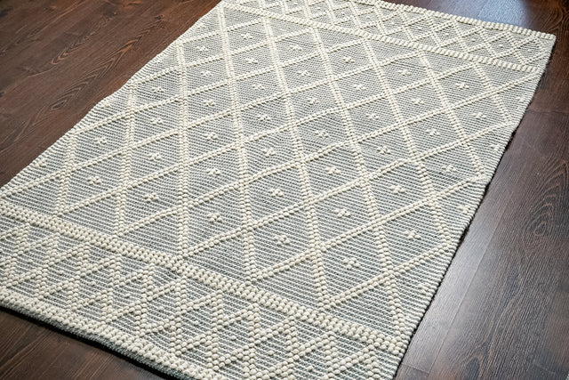 Grey wool rug styled in a living room