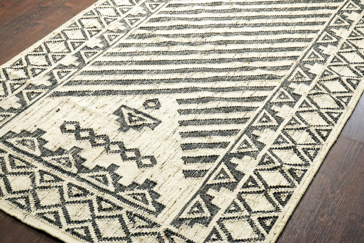 Black and ivory kilim rug styled on a patio