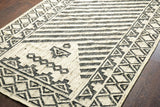 Black and ivory kilim rug styled on a patio