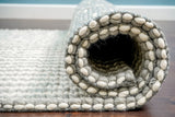 Grey ivory wool rug corner detail with braided edge