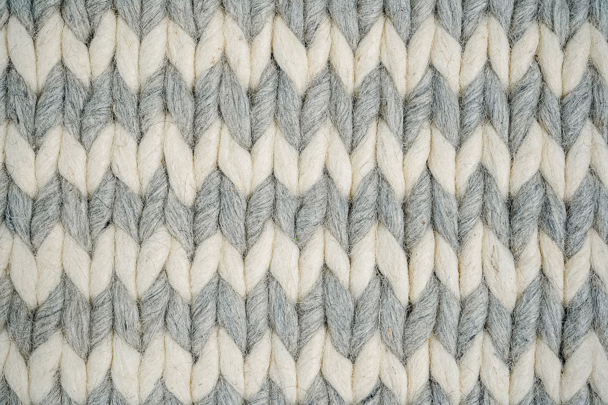 Grey ivory braided rug texture close-up in natural light