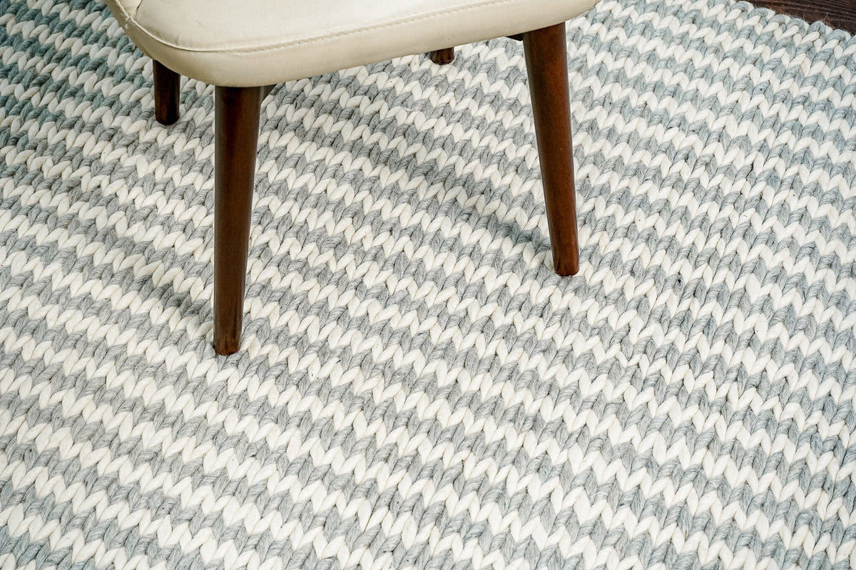 Grey and ivory handwoven wool rug styled in a living room setting