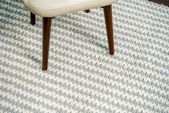 Grey and ivory handwoven wool rug styled in a living room setting