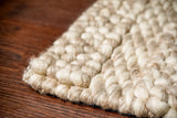 Patterned wool rug styled in a bedroom