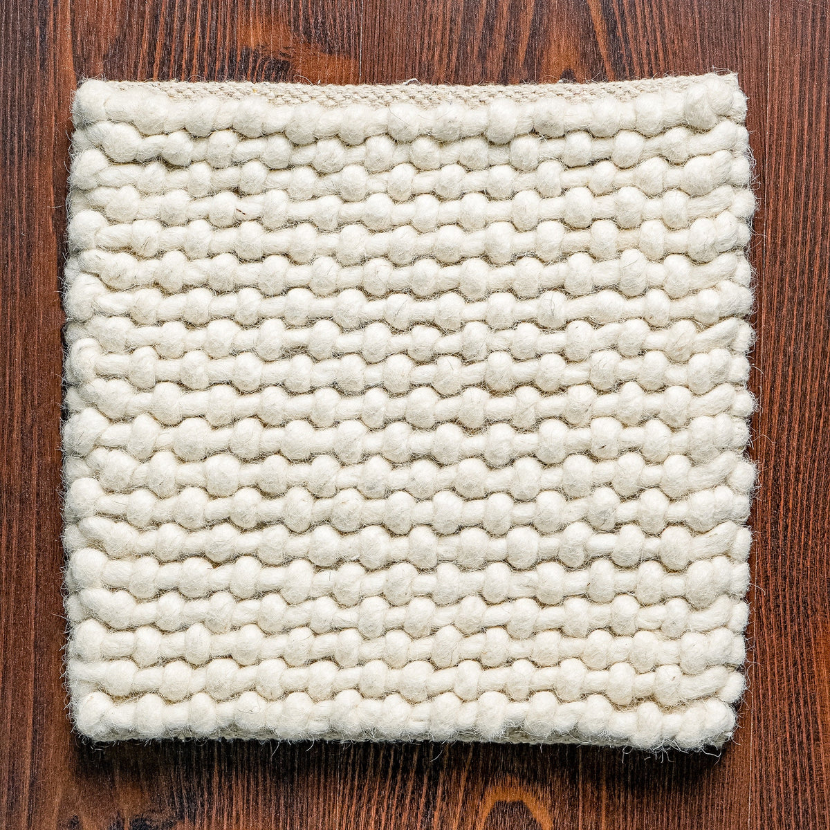 Ivory loop chunky wool rug in bedroom setting