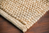 Beige looped wool rug styled in a living room