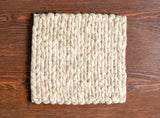 Beige braided wool rug close-up of twisted yarn strands