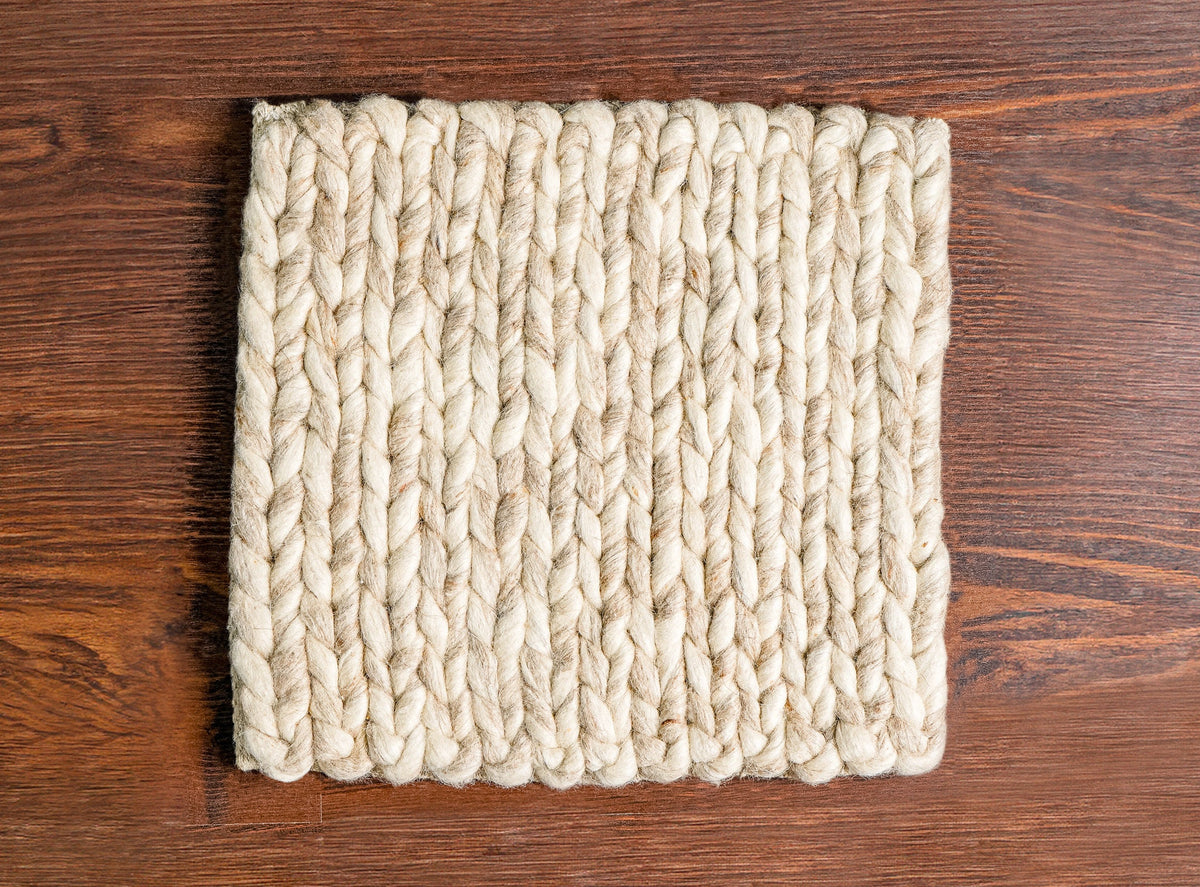 Beige braided wool rug close-up of twisted yarn strands