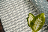 Close-up of chunky braided wool rug pile showing looped texture
