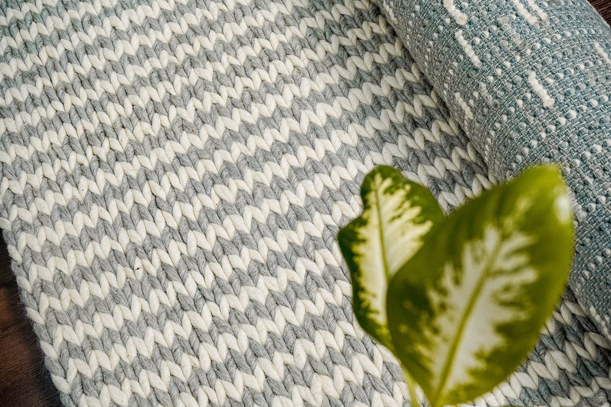 Close-up of chunky braided wool rug pile showing looped texture