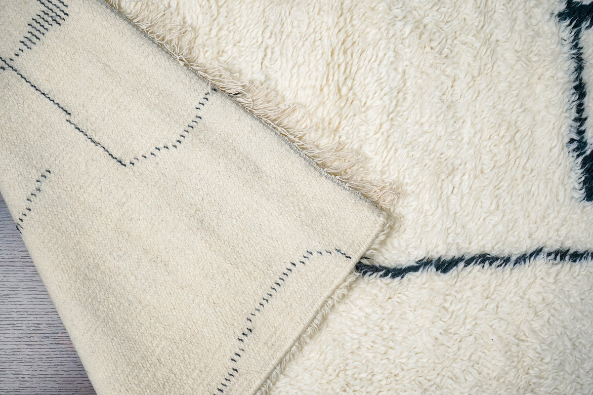 Detail of ivory wool rug edge finishing