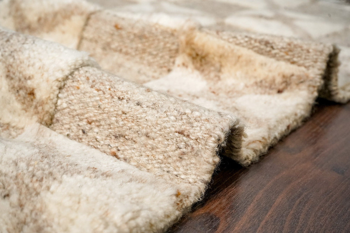 Taupe wool rug in a bedroom setting