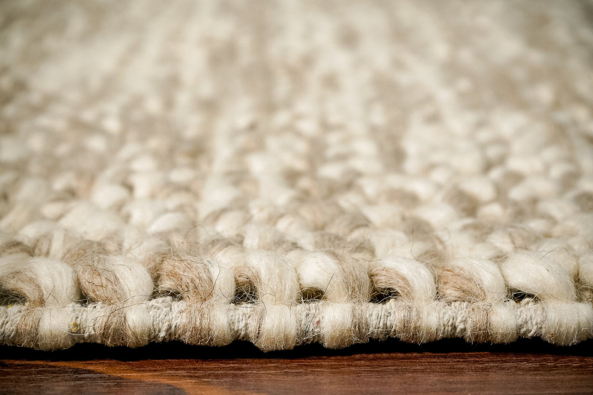 Handwoven taupe wool rug edge and border detail