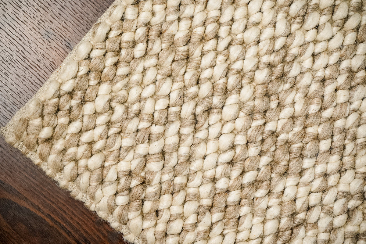 Taupe wool rug styled in a Scandinavian living room