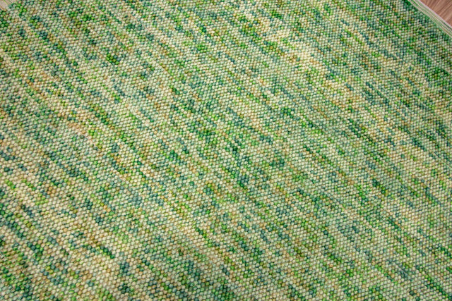 Sage green rug styled in living room