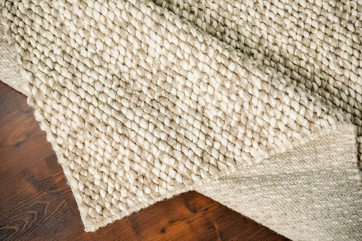 Taupe wool rug under a coffee table lifestyle shot