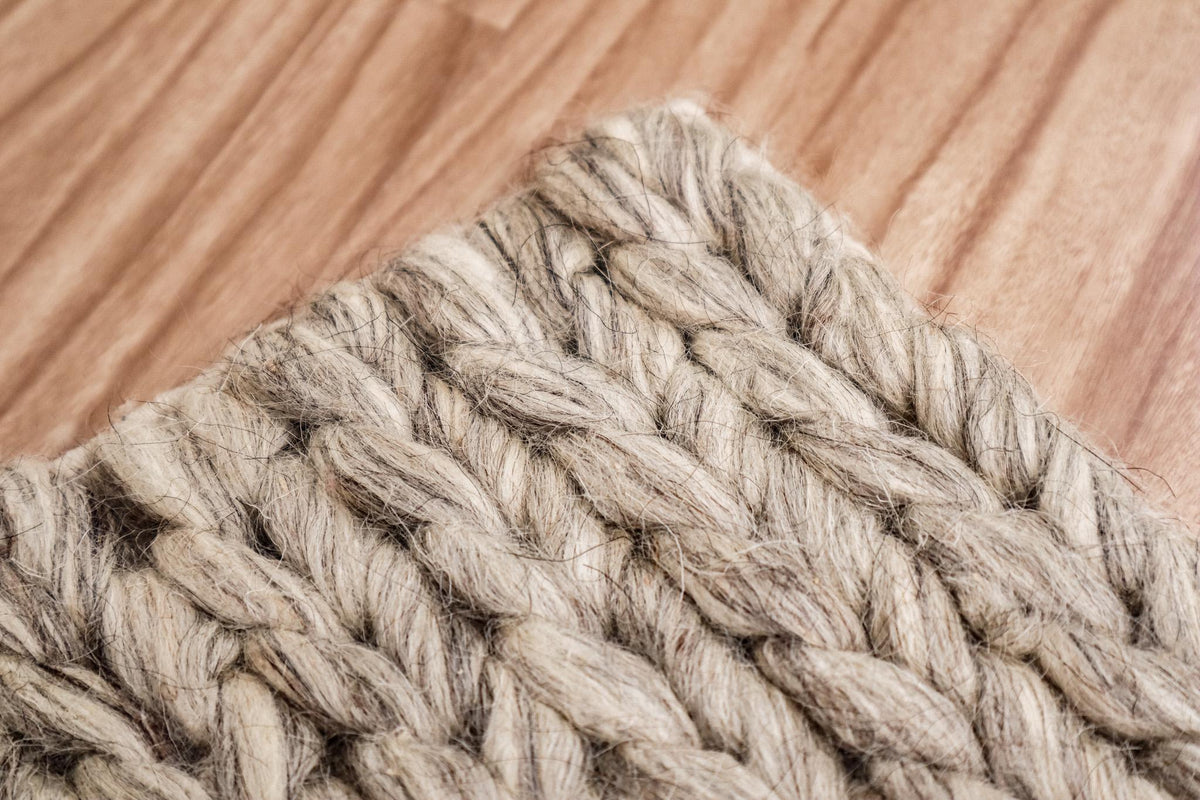 Chunky braided wool rug shown at full size on wood flooring