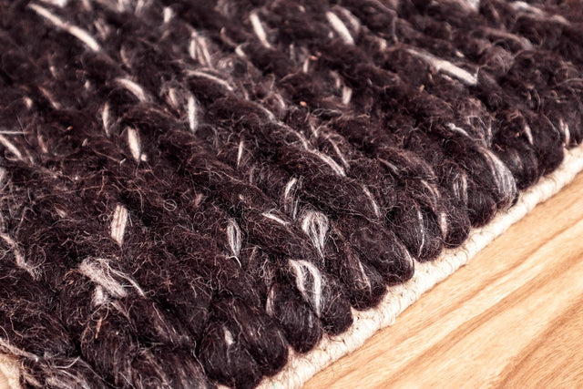 Brown wool rug styled in a living room setting