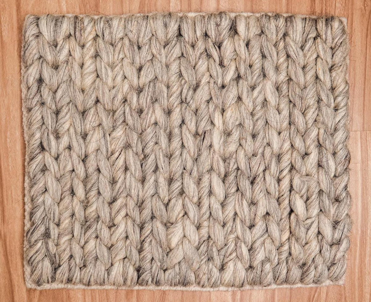 Detail of taupe grey wool rug edge and fringe finishing