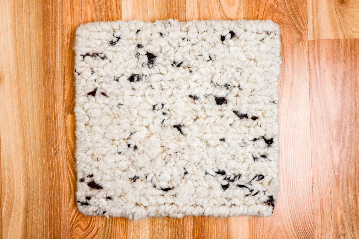 Textured wool rug shown styled with furniture