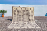 Grey beige rug placed in a minimalist room setting