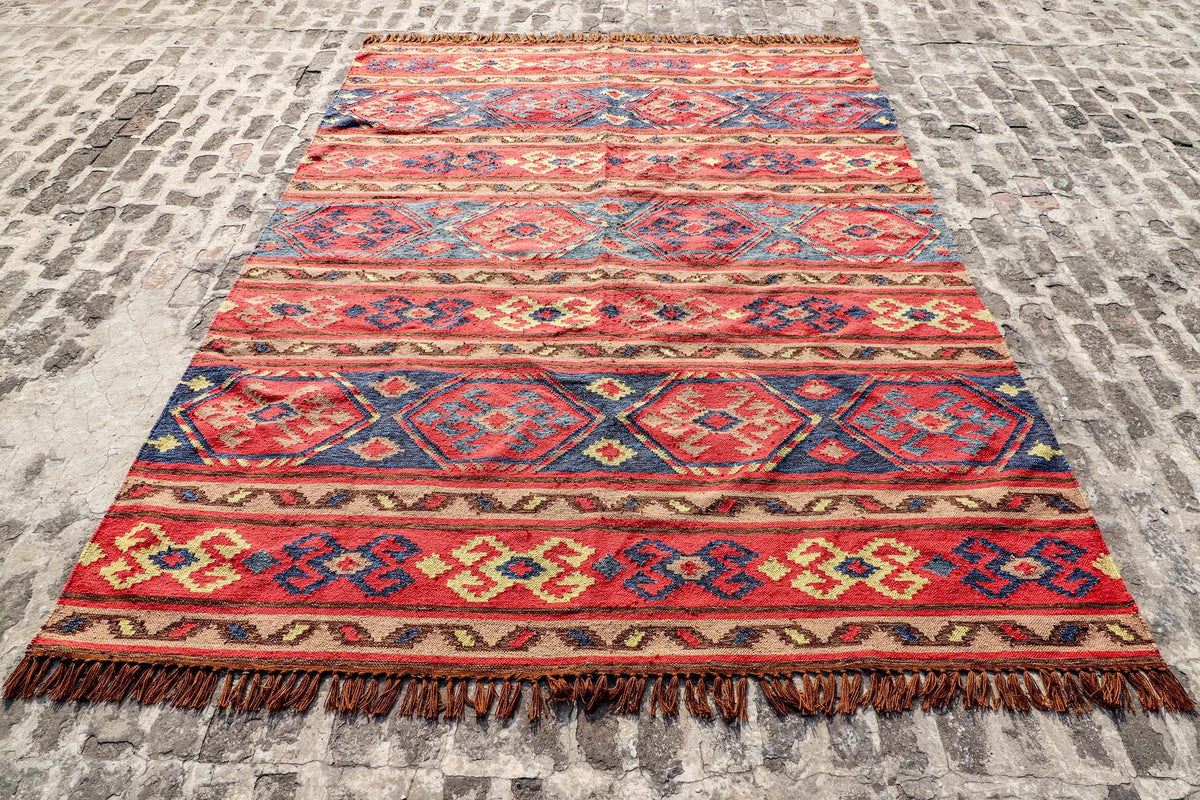 Red Afghan style kilim rug in a living room setting