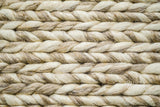 Beige braided wool rug texture macro shot
