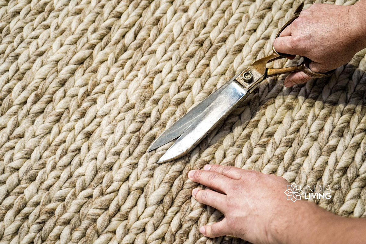 Beige braided wool rug in a bedroom setting