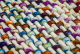 Rainbow wool rug shown styled with furniture