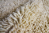 Ivory shag rug styled with neutral decor accents