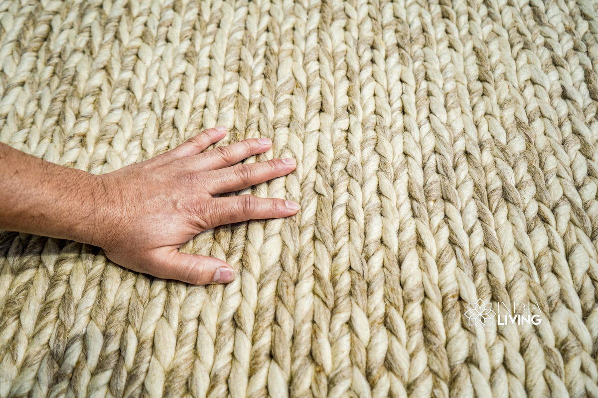 Beige braided wool rug laid in a cozy reading nook