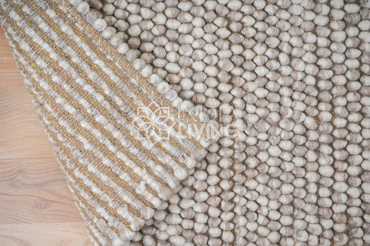 Beige wool rug styled in Scandinavian living room