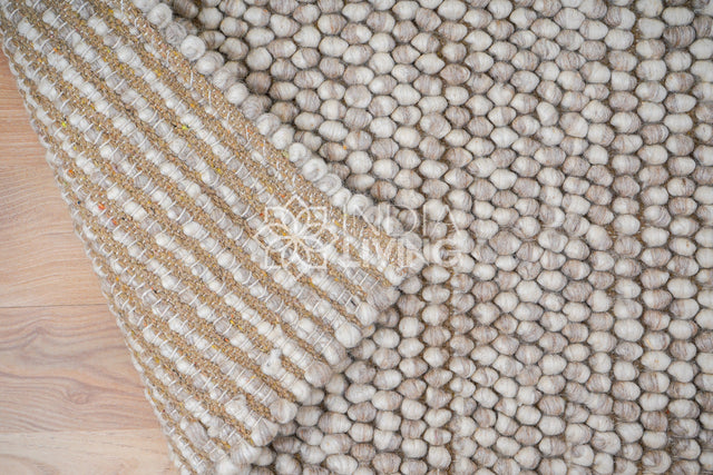 Beige wool rug styled in Scandinavian living room